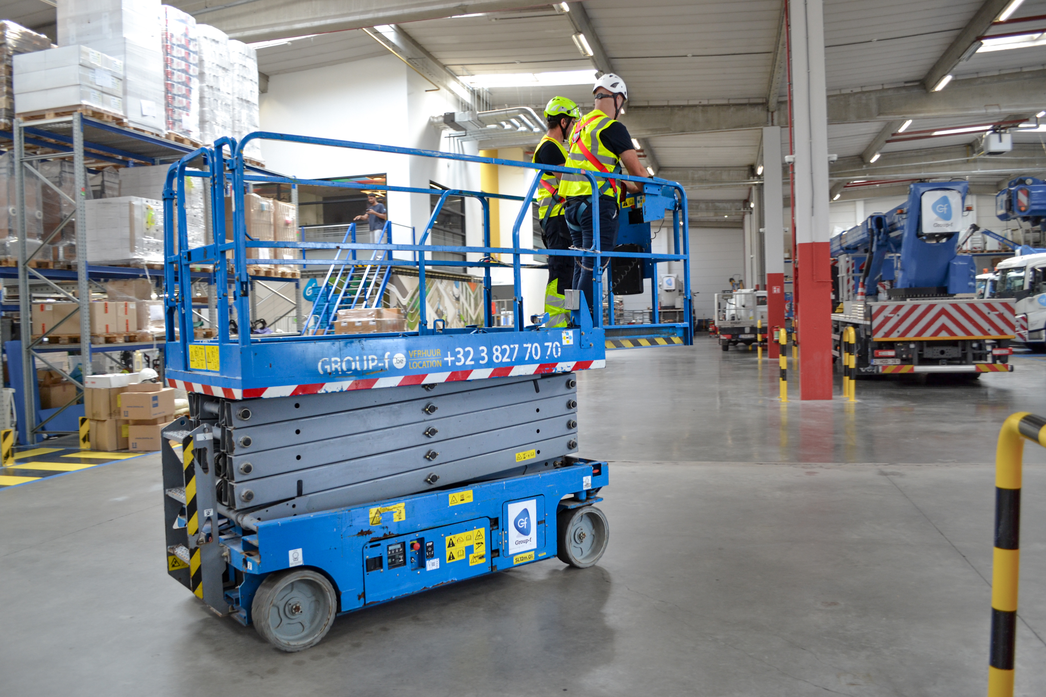 Deelnemers oefenen met de schaarlift in de werkplaats